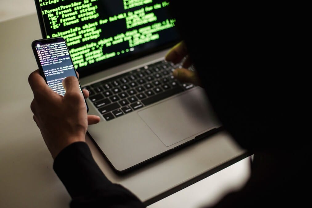 Pantalla de ordenador con código y candado representando la ciberseguridad